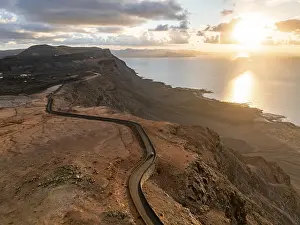 Rocky Shoreline At Sunset Stampe: Road on cliffs in evening light