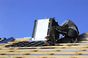 Residential Building Renovation Stampe: Roofer works on the chimney cladding