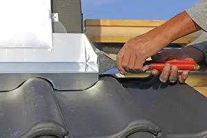 Residential Building Renovation Stampe: Roofer works on the chimney cladding