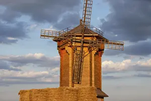 Evening Sun Setting Stampe: A rustic windmill is illuminated by sunset