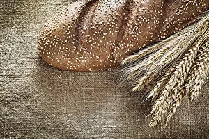 Deserted Bakery Scene Stampe: Rye ears bread on burlap background