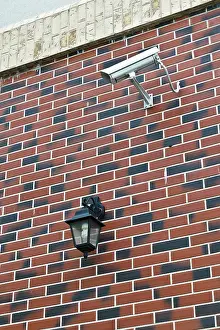 CCTV Camera Installation Stampe: Security camera and flashlight on the wall of the house