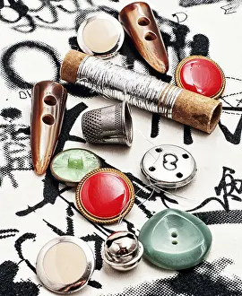 Tailor Tools Stampe: Silver bobbin of thread and a set of buttons