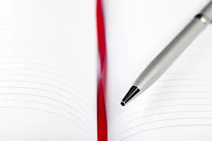 Office Supply Desk Utensils Stampe: Silver pen on opened notebook with red string