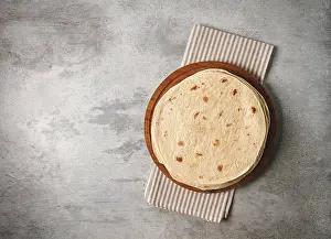 High Calorie Baked Goods Stampe: A stack of Mexican tortillas, on a gray table