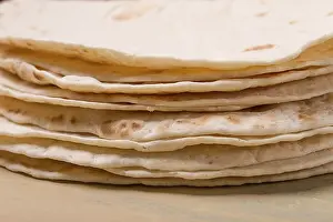 Deserted Table Setup Stampe: A stack of Mexican tortillas, on a gray table