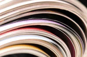 Environmental Conservation Through Reuse Stampe: Stack of open magazines