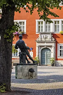 Johann Sebastian Bach Memorial Stampe: A statue in a square in front of a red