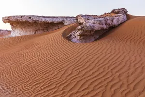 Arabian Peninsula Cliffs Stampe: Striking cliffs surrounded by windswept sand structures