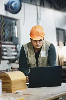 Woodworking Profession Stampe: Successful worker using a computer in the carpentry workshop