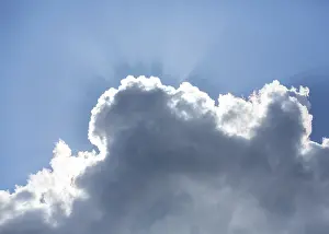 Atmospheric Light Beams Stampe: Sun behind a cloud in the blue sky