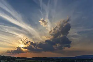 Central Europe Cloudy Skies Stampe: Sun and clouds in the evening sky