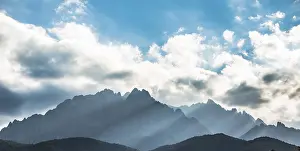 Deserted French Landscape Stampe: Sun through clouds against mountains