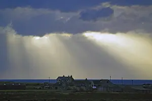 Scottish Coastal Landscape Stampe: Sunbeams break through dramatic clouds over houses by the sea