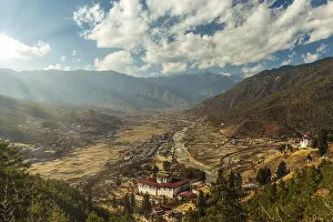 Cloudy Sunset Stampe: Sunrays through the clouds as the sun is setting over Paro