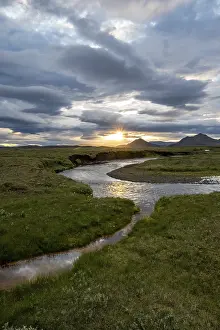 Evening River Scene Stampe: Sunset between clouds, river flowing through meadows