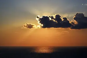 Santorini Sunset Stampe: Sunset behind clouds at the sea