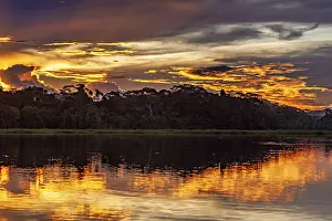 Cloudy Evening Sky Photography Stampe: Sunset over a river with dramatic sky and intense reflections