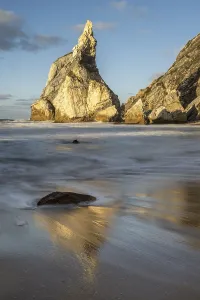 Sandy Ocean Beach Scenery Stampe: Sunset on sandy beach with rocks