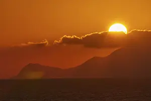 Deserted Island At Sunset Stampe: Sunset, sun disc behind clouds