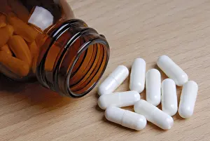 Healthcare System Treatment Stampe: Tablets lying in front of a bottle