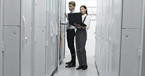 Healthcare Technology Stampe: Technicians using laptop while analyzing server in server room