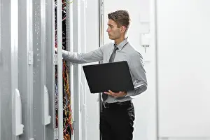 Healthcare Technology Stampe: Technicians using laptop while analyzing server in server room