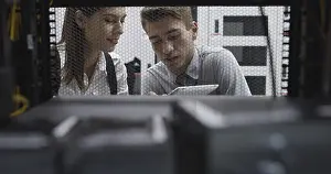Healthcare Technology Stampe: Technicians using laptop while analyzing server in server room