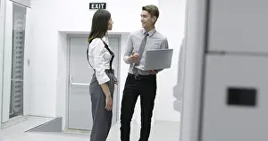Server Room Technician Stampe: Technicians using laptop while analyzing server in server room
