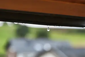 German Weather Stampe: Tiny raindrop hangs on window frame