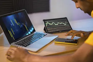Man Working From Home Stampe: Trader using computer and electronic devices to work in remote from home