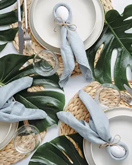 Easter Food Photography Stampe: Tropical Easter Tablesetting. Top view of table setting for Christian Easter with bunny eggs decorated monstera leaves