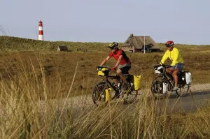 European Lighthouse Photography Stampe: Cyclists in front of the Ostellenbogen Lighthouse