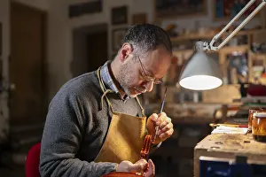 Immagini datate 3 dicembre 2024: Il liutaio lavora su un violino nel suo laboratorio.