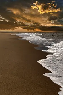 US American Coastal Landscape Stampe: Waves on empty beach, dramatic cloudy sky at sunset