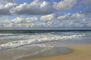 Cumulus Humilis Clouds Stampe: Waves running out at the sandy beach