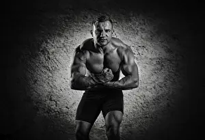 Young Man Posing Stampe: The weightlifter is posing in front of the camera