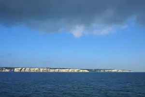 Chalk Cliff Coastline Stampe: White cliffs under a dramatic sky with cloud formations over blue water