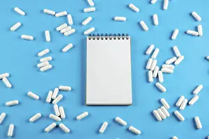 Plain Blue Background Image Stampe: White Notepad on a blue background with tablets