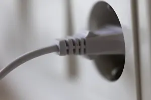 Symbolic Energy Image Stampe: White power plug in a socket on the wall