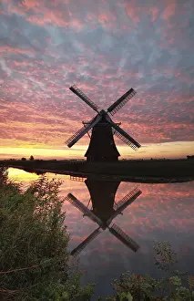 Stampe di Mulino a vento e cielo alba drammatico riflesso nel fiume, Olanda Fiume Stampe: Mulino a vento e cielo al tramonto drammatico riflesso nel fiume.