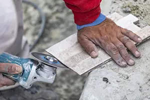 Construction Industry Workers Stampe: Worker grinding corner tile for fitting