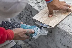 Mason Craftsman Work Stampe: Worker grinding corner tile for fitting
