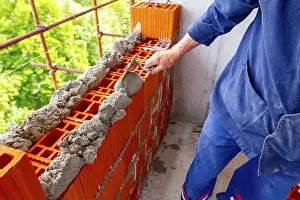 Construction Worker Stampe: Worker is using spatula, trowel