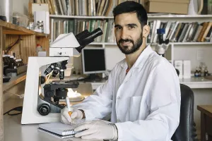 Medical Diagnosis Process Stampe: Young scientist in front of microscope