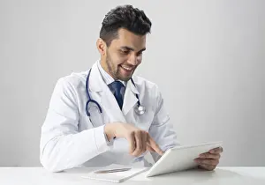 Medical Diagnosis Stampe: Young smiling internist using tablet computer
